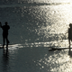 Two clothed people paddleboarding. Image via AP.